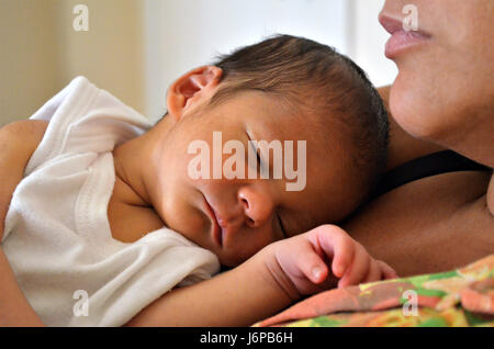 Zehn Tage alten Baby liegend auf der Mutter Schoß nach Krankenpflege. Schlafen ruhig im Laufe des Nachmittags. Stockfoto