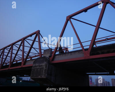 Dieses Foto fängt den pulsierenden Sonnenuntergang über Makati und Mandaluyong City ein und zeigt die urbane Skyline von Metro Manila, während sie in den warmen Farbtönen einer untergehenden Sonne getaucht ist. Stockfoto