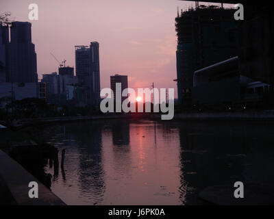 Ein malerischer Blick auf die Häuser der Century City Makati Mall mit Sonnenuntergängen im Makati-Viertel von Metro Manila, die die Skyline der Stadt und die kommerzielle Entwicklung hervorheben. Stockfoto