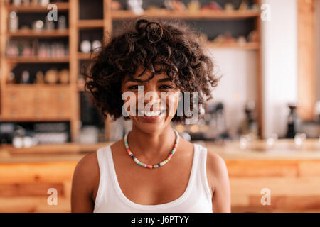 Porträt von schöne junge Frau in einem Café in der Nähe. Lächelnde junge afrikanische Frau in einem Café. Stockfoto