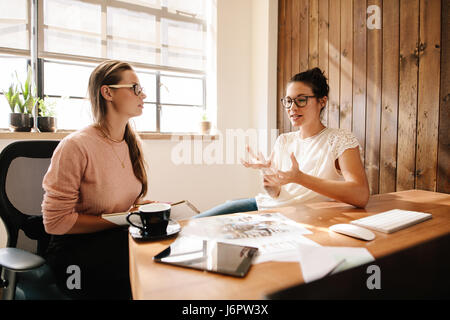 Zwei Geschäftsfrauen diskutieren neue Projektideen am Schreibtisch. Corporate-Profis treffen für neue Geschäftsideen. Stockfoto