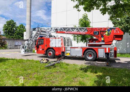 Seitlicher Blick auf einen Leiterwagen einer Schweizer Feuerwehr Iveco Magirus 160E30 Plattenspieler. Ausleger/Buchsen erweitert, aber Leiter noch eingefahren. Stockfoto