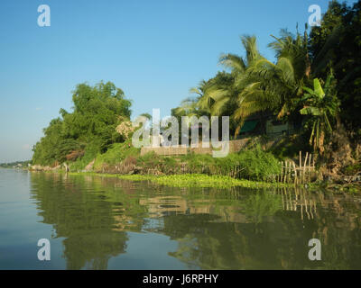 Dieses Bild zeigt die ruhigen Flussviertel Calumpit, Bulacan und Apalit, Pampanga. Es unterstreicht die malerische Landschaft mit klarem blauen Himmel und zeigt die natürliche Schönheit der Dörfer und umliegenden Gebiete auf den Philippinen. Stockfoto