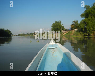 Dieses Bild zeigt einen ruhigen Blick auf die Flussviertel auf den Philippinen, insbesondere auf den blauen Himmel und die Dorflandschaften von Calumpit, Bulacan und Apalit, Pampanga. Es zeigt das ländliche Leben und die natürliche Schönheit. Stockfoto
