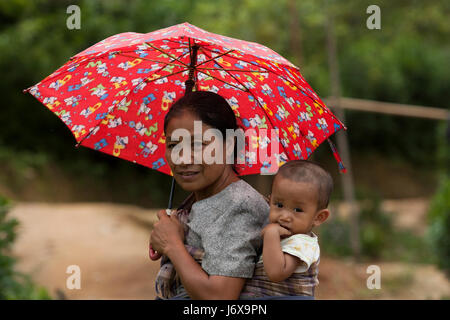 Eine ethnische Mutter trägt ihr Baby auf dem Rücken. Khagrachari, Bangladesch. Stockfoto