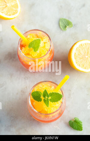 Gefrorene Granita Slush trinken Wein auf rustikalen Steintisch. Hausgemachte italienische Granita Dessert, erfrischende Sommer Gradient tropischen Slush trinken mit Minze. Stockfoto