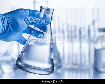 Labor-Becher in der Hand des Analytikers in Kunststoff-Handschuh. Stockfoto