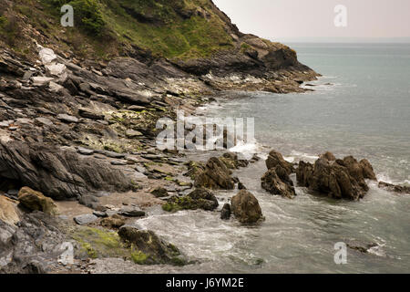 Großbritannien, Cornwall, St Austell, Polkerris, Wellen brechen sich am felsigen Ufer Stockfoto