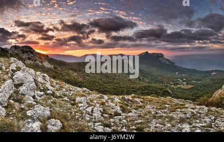 Sonnenaufgang mit Gewitterwolken über das Meer und die Berge Stockfoto