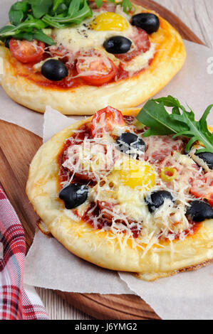 Mini Pizza mit Würstchen und Ei und Rucola für Frühstück Stockfoto