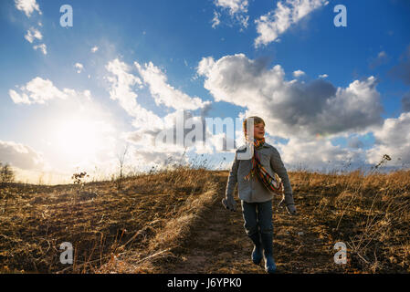 junge hinunter einen Hügel an einem windigen Tag Stockfoto