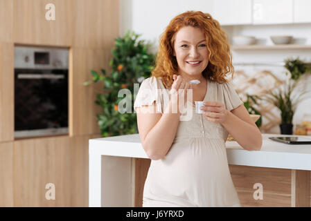 Lächelnde werdende Mutter gesund frühstücken Stockfoto