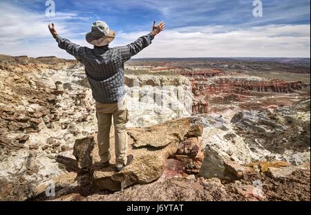 Wanderer auf Berggipfel mit ausgestreckten Armen stehend, Grand Staircase-Escalante National Monument, Utah, USA Stockfoto