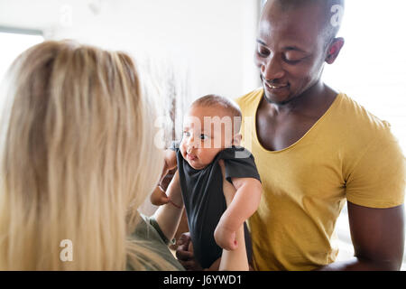 Interracial junge Familie mit Baby Söhnlein zu Hause. Stockfoto