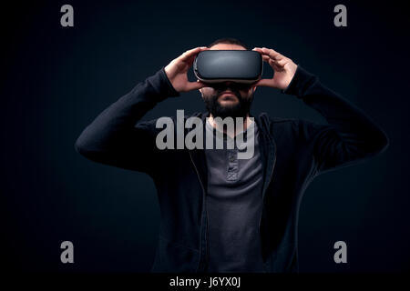 Junge hipster bärtigen Mann mit Virtual reality Brillen. schwarzer Hintergrund Studio VR-Konzept Stockfoto