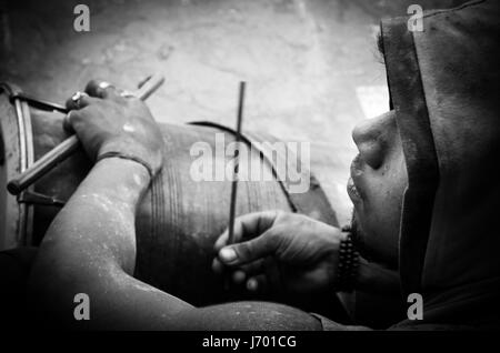 eine monochrome Bild von einer indischen Schlagzeuger mit Stöcken in Händen Stockfoto