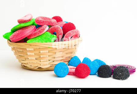 Korb mit verschiedenen bunten Bonbons auf weißem Hintergrund Stockfoto