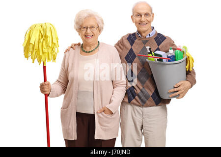 Senioren mit einem Wischmopp und Eimer gefüllt mit Reinigungsmitteln, die in die Kamera schaut und lächelt auf weißem Hintergrund isoliert Stockfoto