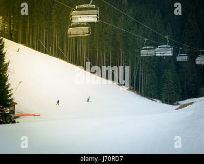 Skifahrer und Snowboarder auf einer Skipiste in Jasna Chopok in Slowakei Skigebiet fahren. Stockfoto