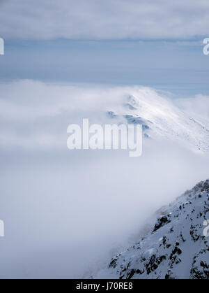 Höchste Punkte der Niederen Tatra - Chopok Peak und Dumbier Peak (Slowakei). Wunderschönen Winterbergen Landschaft über den Wolken. Stockfoto