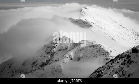 Höchste Punkte der Niederen Tatra - Chopok Peak und Dumbier Peak (Slowakei). Wunderschönen Winterbergen Landschaft über den Wolken. Stockfoto