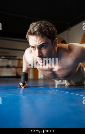 Vertikales Bild eines Boxers doing Push-Ups im Boxring Stockfoto