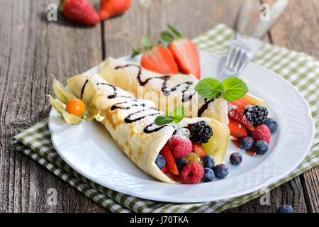 Zwei hausgemachte Pfannkuchen gefüllt mit frischen Waldbeeren Stockfoto