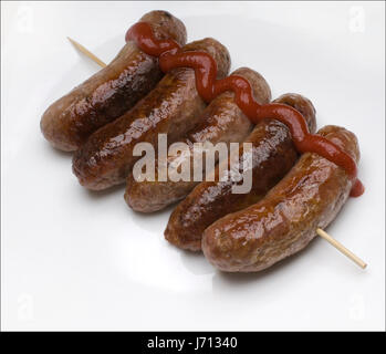 Fünf Würstchen auf einem Holzstäbchen mit Tomatensauce auf der rechten Seite Stockfoto