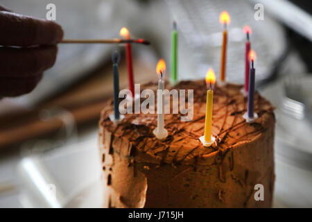 Anzünden von Kerzen auf Schokolade Geburtstagskuchen Stockfoto