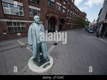 Rüsselsheim, Deutschland. 22. Mai 2017. Eine Bronzestatue des Unternehmens Gründer Adam Opel außerhalb der historischen Opel Eingangsportal im Zentrum von Rüsselsheim, Deutschland, 22. Mai 2017. Der Konzeptkünstler Ottmar Hoerl will eine neue Gruppe von Skulpturen auf dem Platz vor dem Bahnhof, im Auftrag der Stadt Wohnungsbaugesellschaft einrichten. Die Stadt und Denkmal Naturschützer dagegen, da die Statue von Adam Opel und einem historischen Gebäude des Auto-Herstellers sind in unmittelbarer Nähe. Foto: Andreas Arnold/Dpa/Alamy Live-Nachrichten Stockfoto