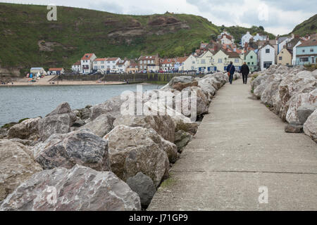 Staithes, UK. 22. Mai 2017. Großbritannien Wetter. Warmer Tag aber grauen Himmel über das Meer in Staithes, einem malerischen Fischerdorf in North Yorkshire, UK. Menschen zu Fuß entlang der Strandpromenade genießen das warme Wetter. David Dixon/Alamy Live-Nachrichten Stockfoto