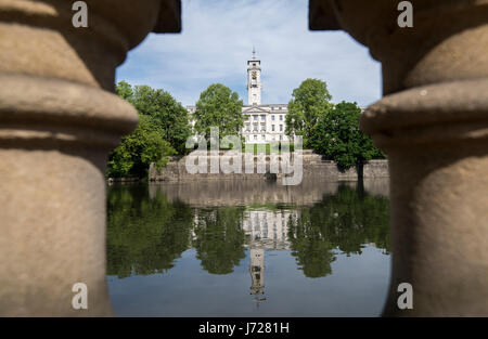 Trent Gebäude betrachtet durch Spalten und spiegelt sich in den See mit Booten bei Highfields University Park, Nottingham England UK Stockfoto