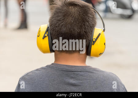 Kleiner Junge schützende Kopfhörer tragen, um sich vor Lärm zu schützen Stockfoto