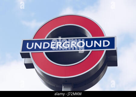 London, UK - 2. April 2017: London Underground Schild mit blauen Himmel und Wolken Stockfoto