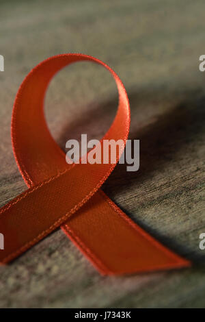 Nahaufnahme von einem orangefarbenen Band platziert auf einer rustikalen Holzoberfläche Stockfoto