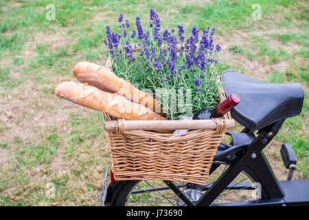 Fahrrad mit Korb und Wein mit Brot, Blumen zu Stockfoto