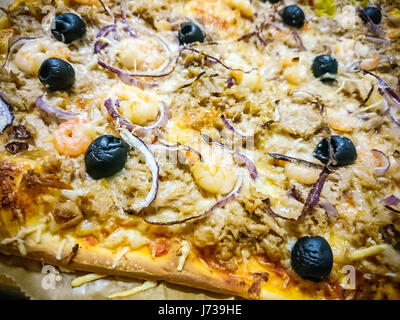 Gebackener Thunfisch Pizza mit Garnelen und schwarzen Oliven Stockfoto