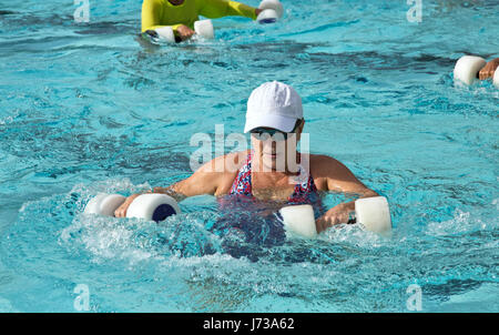 Ältere Frau mit "Wasser-Hanteln", Aerobic-Kurs, beheizten Außenpool, Rockport, Texas. Stockfoto