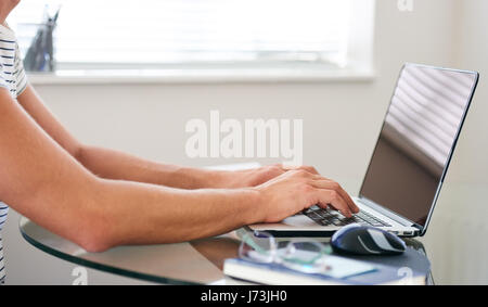 Zugeschnittenes Bild komponiert Man Hände auf einem Laptop eingeben Stockfoto