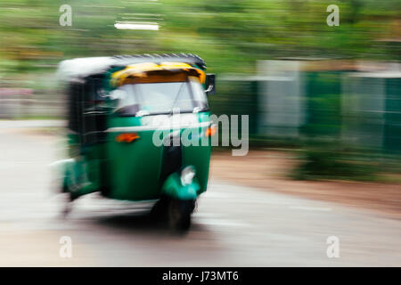 Ein grüne Tuktuk (Rikscha) vergrößert durch die Straße in Anuradhapura, Sri Lanka. Stockfoto