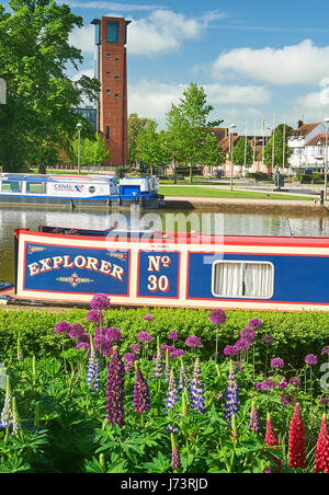 Hausboote in Bancroft-Becken in Stratford-upon-Avon mit dem Turm für das Royal Shakespeare Theatre im Hintergrund Stockfoto