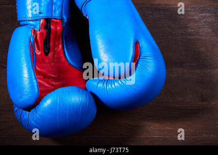 Nahaufnahme eines Paares von blauen und roten Boxhandschuhe an der hölzernen Wand hängen. Stockfoto