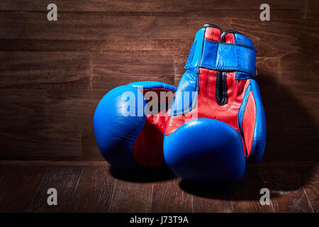 Nahaufnahme des Paares von roten und blauen Boxhandschuhe auf das Holzbrett. Stockfoto