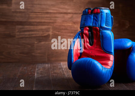 Nahaufnahme des Paares von roten und blauen Boxhandschuhe auf das Holzbrett. Stockfoto