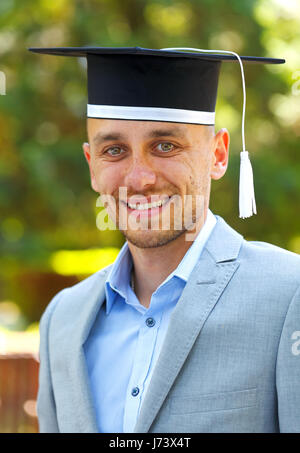 Happy graduateing Student trägt die Staffelung hat Stockfoto