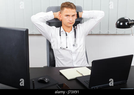 Foto von einem stressigen jungen männlichen Arzt in seinem medizinischen Büro Stockfoto