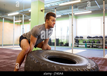 Mann tut Strongman Reifen flip Training im Fitness-Studio Stockfoto