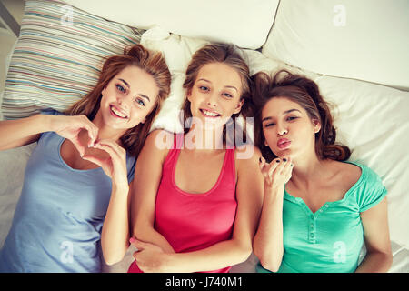 glückliche junge Frauen im Bett zu Hause Pyjama-party Stockfoto