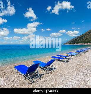 Sommer morgen kiesiger Strand mit Sonnenliegen (Albanien). Stockfoto