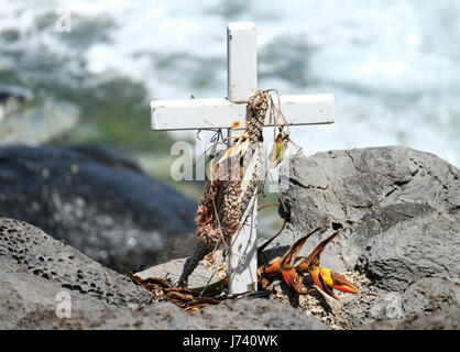 Ein Kreuz, ein Denkmal für gefallene Surfer an der Küste am Hookipa Beach Park, Paia, Maui, Hawaii. Stockfoto